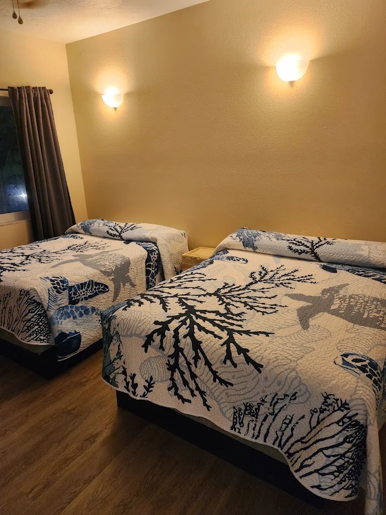 Villa bedroom with two beds dressed in sea turtle and coral quilts